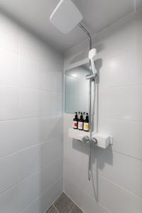 a white bathroom with a shower with a mirror at Stayz437 Jongno in Seoul +100 photos
