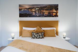 a bedroom with a bed with a picture on the wall at Douro Garden and Rooftop Home 1 in Vila Nova de Gaia