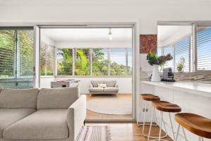 a living room with a couch and a table at Luxury 2-Bed with Ocean Views and Garden in Collaroy +8 photos