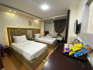 a hotel room with two beds and a television at Golden Pyramids View Inn in Cairo