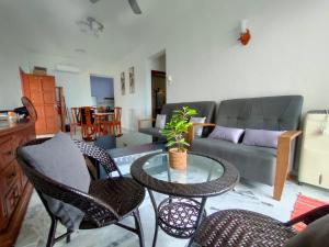 波德申Teaz Apartment at Glory Beach Resort的客厅里有一张沙发、一张桌子和几把椅子。