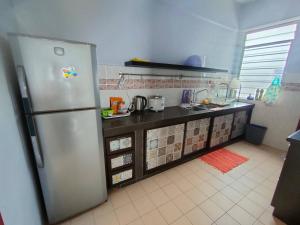 a kitchen with a stainless steel refrigerator in it at Teaz Apartment at Glory Beach Resort in Port Dickson