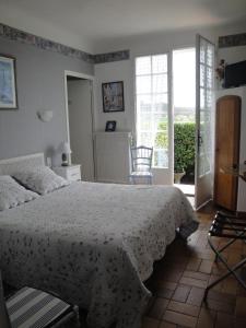 een slaapkamer met een bed met een witte sprei bij Chez Nanie in Mane