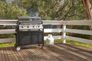 a barbecue grill on a deck with a fence at The little Beach Retreat in Anglesea