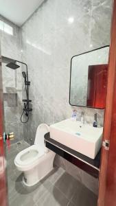a bathroom with a toilet and a sink and a mirror at BTB Homestay in Phumĭ Kâmpóng Âmpĭl +8 photos