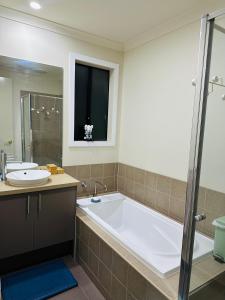 a bathroom with a large tub and a sink at Central Nest at Caroline Springs in Caroline Springs +10 photos