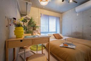 a bedroom with a bed and a table with a vase on it at Ueno Grand Maison Hotel in Tokyo