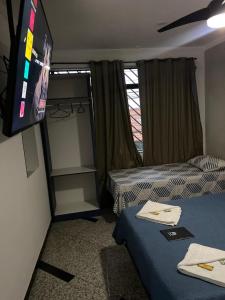 a hotel room with a bed and a tv at Hostel Anprado 4 kit café incluso, Próx-Aeroporto de Guarulhos in Guarulhos