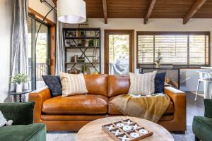 a living room with a brown leather couch at The Pine Perch in Munds Park +85 photos