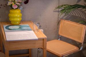 a table with a book and a yellow vase on it at Ueno Grand Maison Hotel in Tokyo