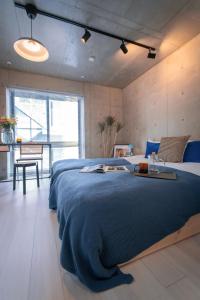 a bedroom with a large bed with a blue blanket at Ueno Grand Maison Hotel in Tokyo +11 photos