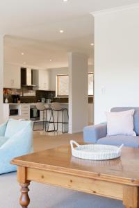 ein Wohnzimmer mit einer blauen Couch und einem Tisch in der Unterkunft Mount Lofty Golf Course in Bridgewater