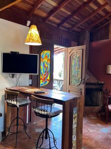 a room with a desk with chairs and a television at Chalés ANECUEM in Monte Verde