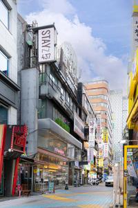 a busy city street with buildings and signs at Stayz437 Jongno in Seoul
