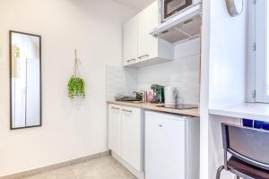 a kitchen with white cabinets and a counter top at Studio Le Saphir NEUF & Cosy - Gare Parilly in Vénissieux