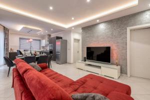 a living room with a red couch and a television at Luxury Cosy 3 Bedroom Apt in Gzira, close to Sliema StJulians by walk in Il-Gżira
