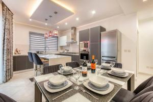a dining room and kitchen with a table and chairs at Luxury Cosy 3 Bedroom Apt in Gzira, close to Sliema StJulians by walk in Il-Gżira