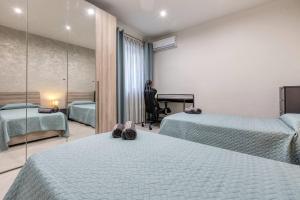 a hotel room with two beds and a mirror at Luxury Cosy 3 Bedroom Apt in Gzira, close to Sliema StJulians by walk in Il-Gżira
