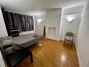 a bedroom with a bed and a chair in it at East Croydon in South Norwood +76 photos