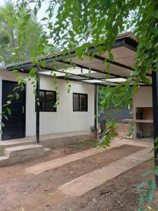 una casa bianca con una porta nera di Flor de Espinillo Estancia Grande a Estancia Grande