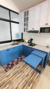 a kitchen with blue cabinets and a counter top at Dirumahjogja - Villa 2 in Jarakan