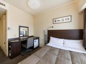 a hotel room with a bed and a desk and a computer at The OneFive Okayama - Vacation STAY 41845v in Okayama +21 photos