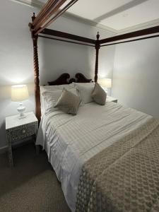a bedroom with a large bed with a wooden canopy at 3 Br home with kitchen in Beaconsfield