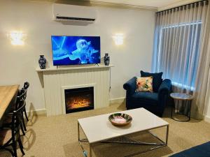 a living room with a fireplace with a flat screen tv at Montecello in Beaconsfield