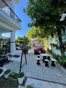 フエにあるNhat Long Homestayの車の横の歩道のテーブルと椅子