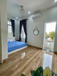 a bedroom with a blue bed and a window at Nhat Long Homestay in Hue