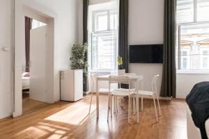 ein Wohnzimmer mit Tisch und Stühlen in der Unterkunft Comfortable 2BR Apt Central & Well Connected in Wien