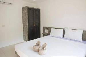 a bedroom with a white bed with two baskets on it at Cozy 1br Shared Pool & Sea View In Chaweng in Koh Samui 