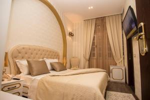 - une chambre d'hôtel avec un lit et un miroir dans l'établissement Hotel Boutique Restaurant Gloria, à Tirana