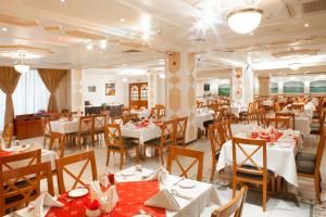 a dining room with white tables and chairs and a restaurant at Landmark Hotel in Dubai
