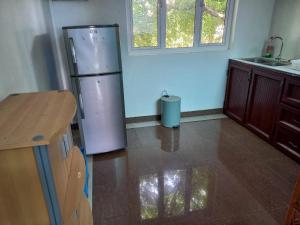 a kitchen with a stainless steel refrigerator and a table at Lariad BNB in Rivière Noire