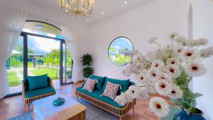 a living room with two chairs and a large vase of flowers at Nhà Vườn NGô Tất Tố , lộc châu , TP bảo lộc in Ðại Lào