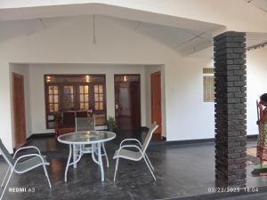 a dining room and living room with a table and chairs at Solaces transit residence in Liyanagemulla