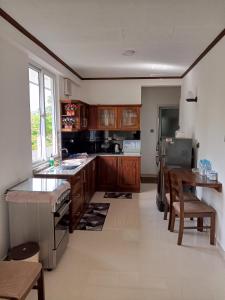 a large kitchen with wooden cabinets and a table at 682 Villa Weligama in Weligama