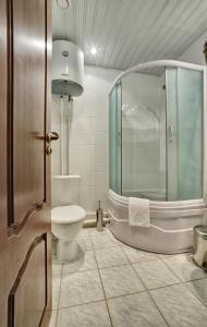 a bathroom with a toilet and a glass shower at Vernisage on Ushinskogo in Saint Petersburg