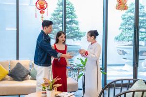 a group of three people standing in a living room at CENTRAL PLAZA HOTEL - Mỹ Tho in Mỹ Tho