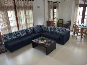 un salon avec un canapé bleu et une table dans l'établissement Green Woods, à Colombo