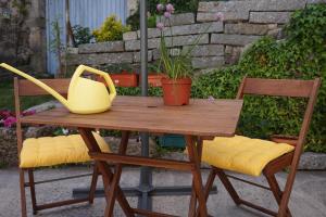a wooden table with two chairs and a yellow purse on it at Casa de Campo Neves in Montalegre