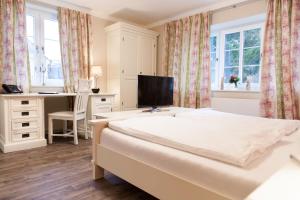 a bedroom with a bed and a desk and a television at Pension am Werbellinkanal in Eichhorst