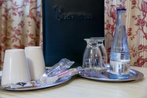 a table with a plate with a bottle of water and candles at Pension am Werbellinkanal in Eichhorst
