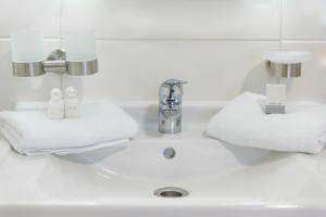 a white bathroom sink with towels on it at Pension am Werbellinkanal in Eichhorst +13 photos