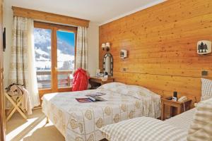 Cama ou camas em um quarto em Hôtel Vacances Bleues Les Chalets du Prariand