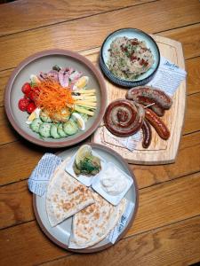 three plates of food on a wooden table at Cachet Boutique Kunming Artime in Kunming