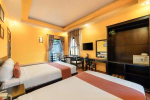 a hotel room with two beds and a desk at Golden Bell Homestay in Hoi An