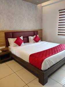 Un dormitorio con una cama grande con almohadas rojas. en Mayuri Residency, en Bangalore
