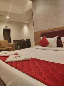 Una habitación de hotel con dos camas con almohadas rojas. en Mayuri Residency, en Bangalore